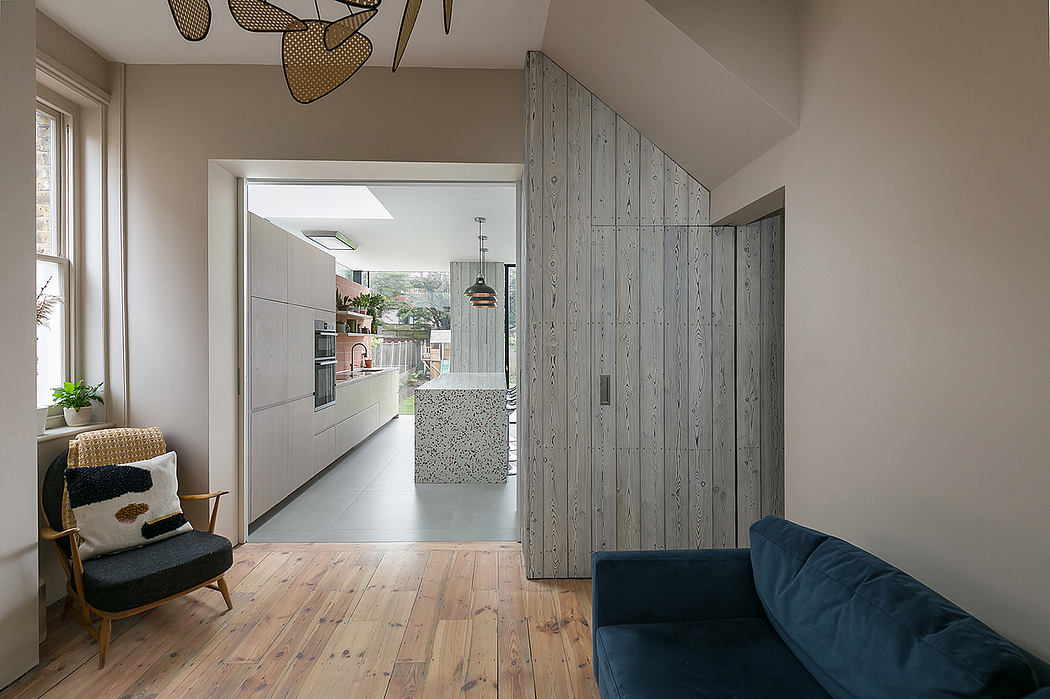 Inviting open-concept home with sleek wood paneling, modern kitchen, and cozy furnishings.