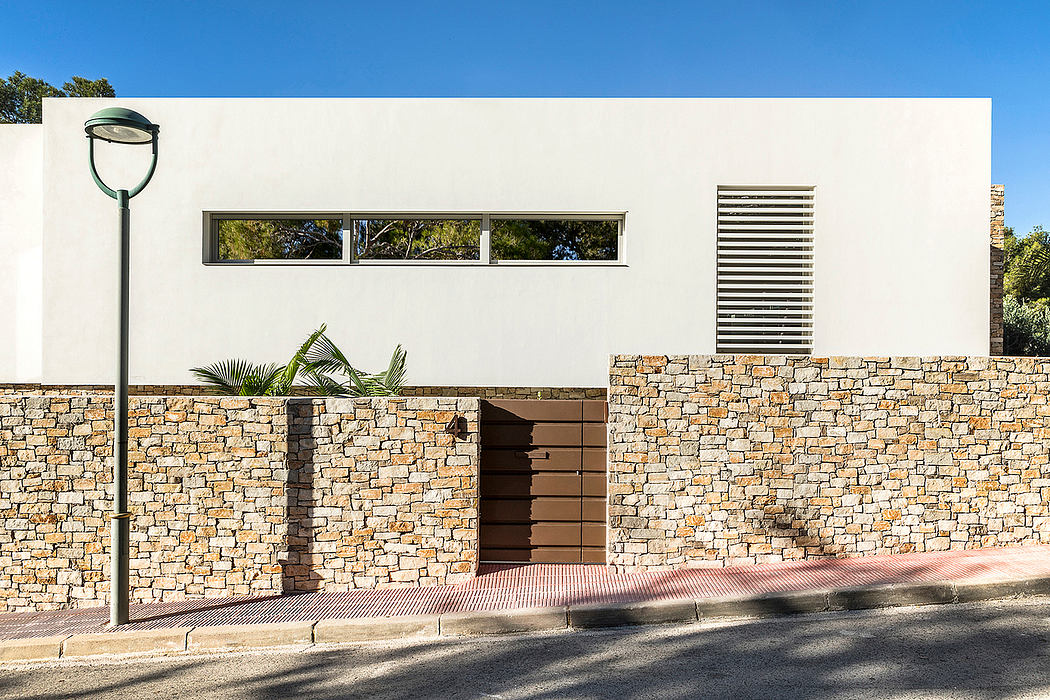 A minimalist building with a stone exterior, large windows, and modern architectural features.