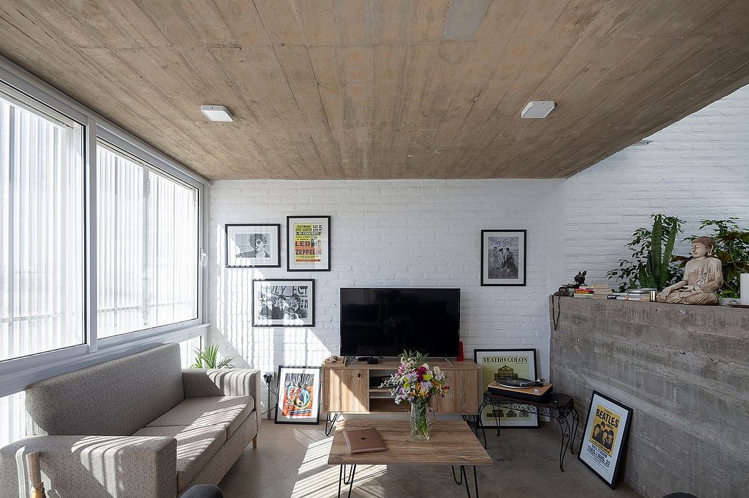 A cozy living room with wooden ceiling, brick walls, and an eclectic mix of furniture and art.