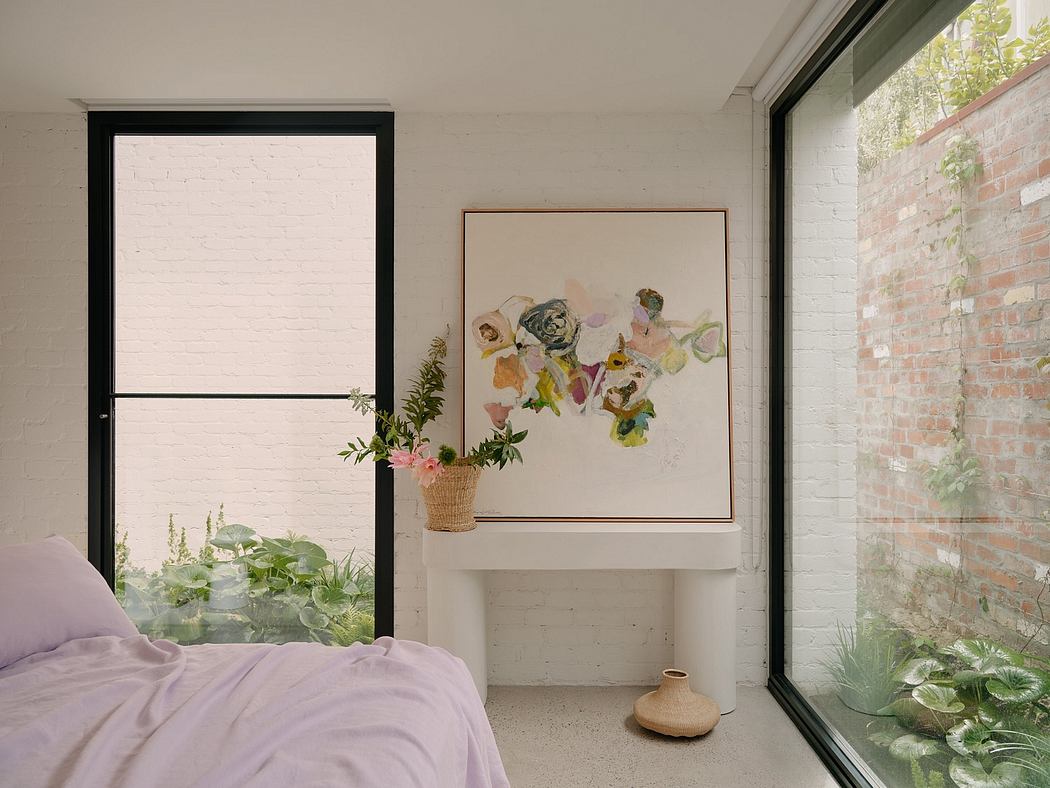 Airy bedroom with large windows, white brick wall, and abstract floral artwork.