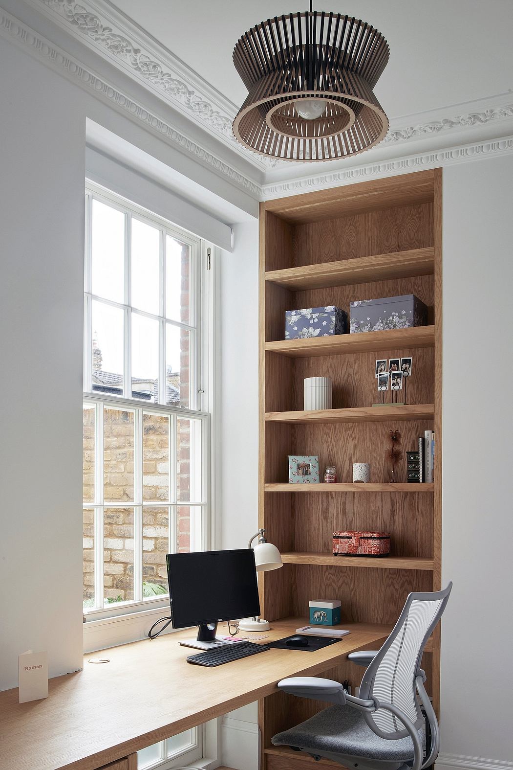 Elegant built-in shelving, modern pendant light, and spacious workstation in refined room.