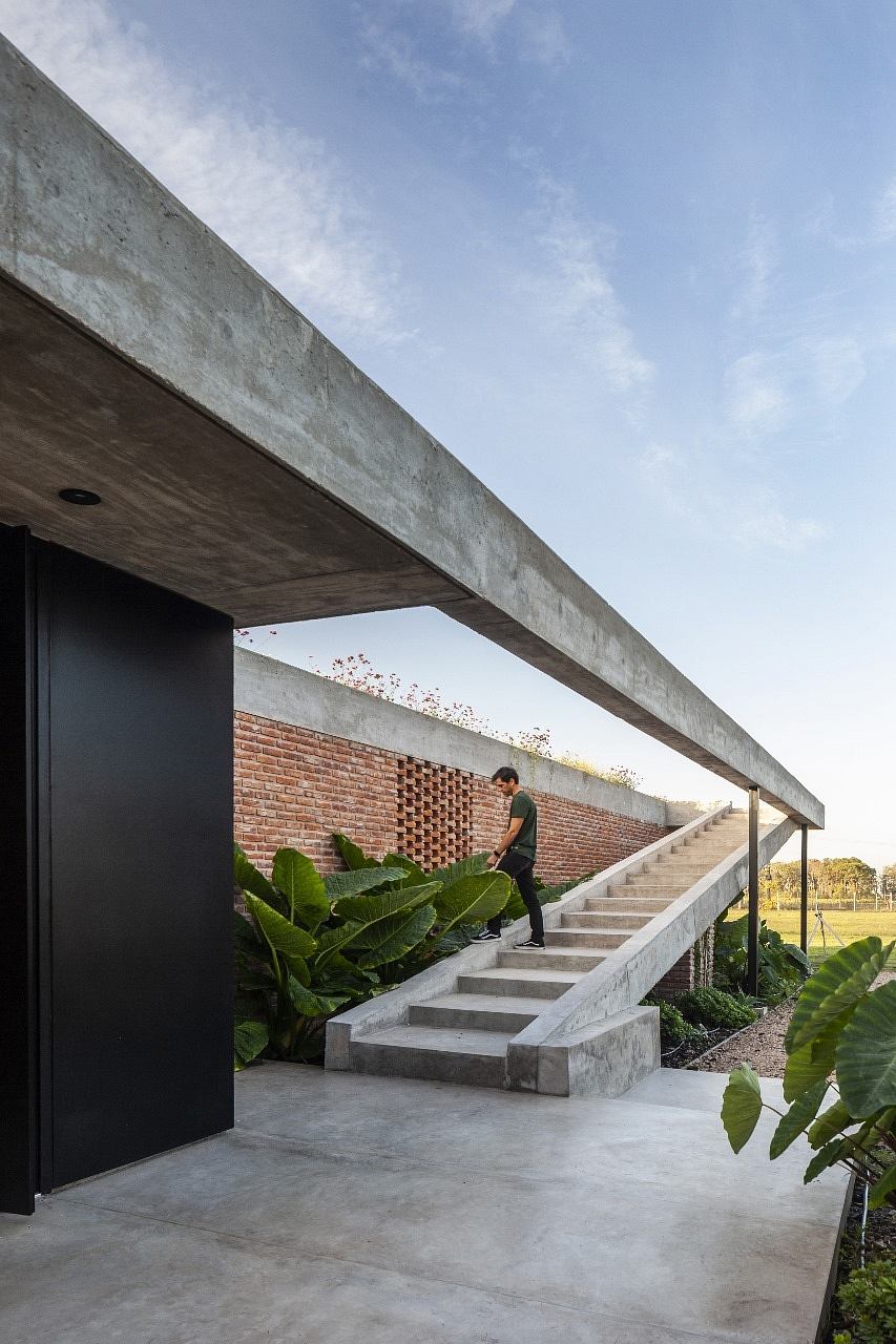 Concrete structure with brick walls, stairs, and lush vegetation surrounding the exterior.