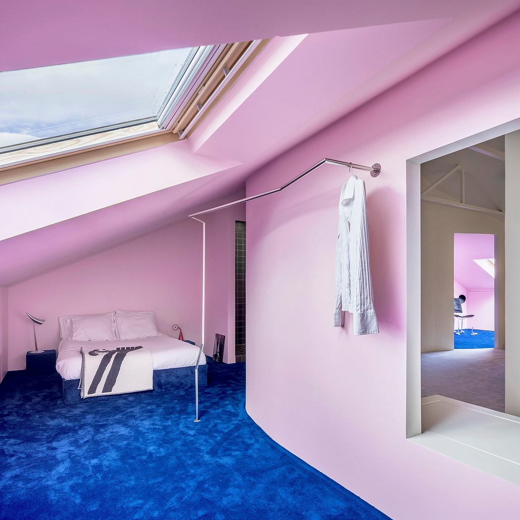 A bright, modern bedroom with a blue carpet, pink walls, and a skylight window.