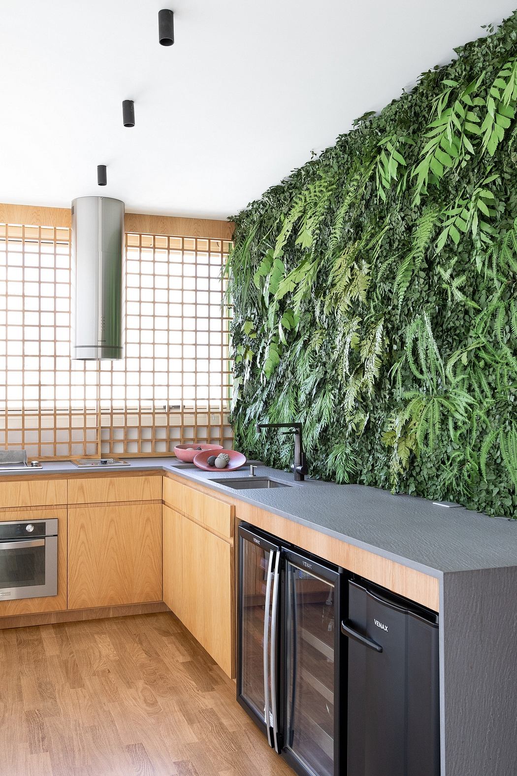 Sleek kitchen design with a striking green plant wall and modern appliances.