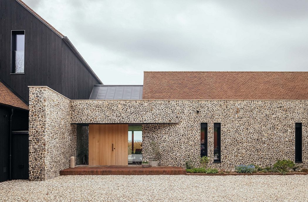 A modern farmhouse-style exterior with a stone facade, wooden entry, and large windows.