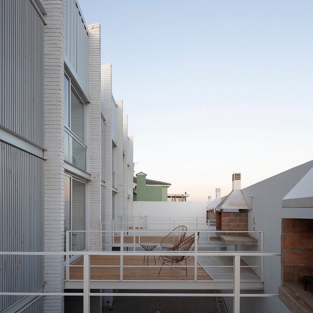 Modern city apartment with sleek balcony, cozy seating area, and outdoor grill.