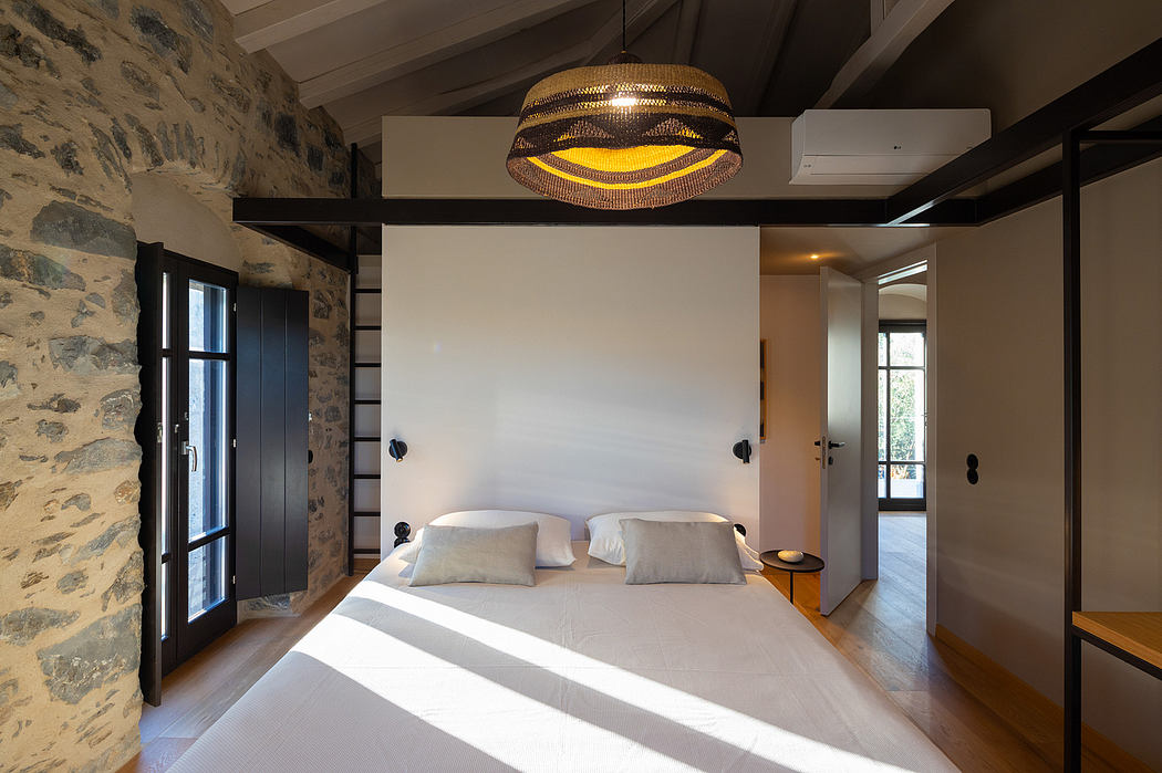 Rustic stone walls, sleek black-framed doors, and a striking circular light fixture create a warm, cozy atmosphere.