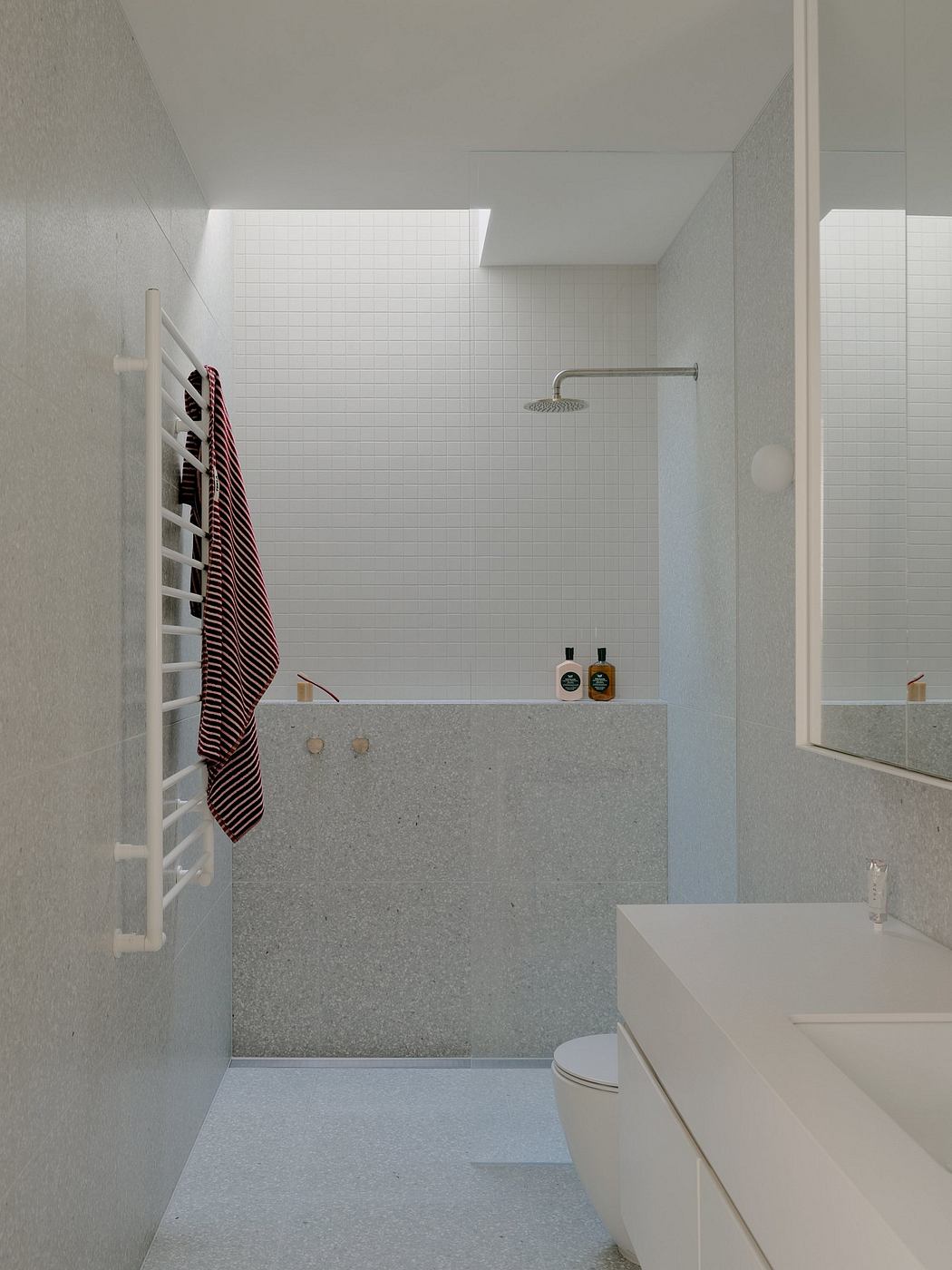Clean and minimalist bathroom with tiled walls, granite countertop, and modern fixtures.