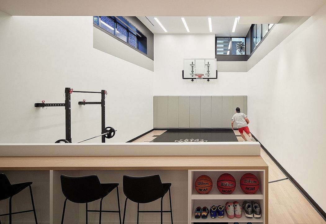 Well-designed home gym with modern architecture, high ceilings, and ample storage for athletic equipment.