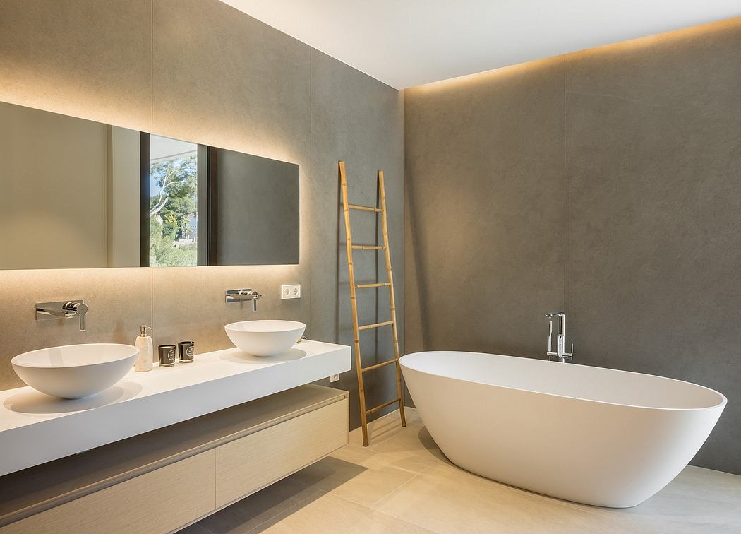 Modern bathroom with dual sink vanity, freestanding tub, and bamboo ladder decoration.