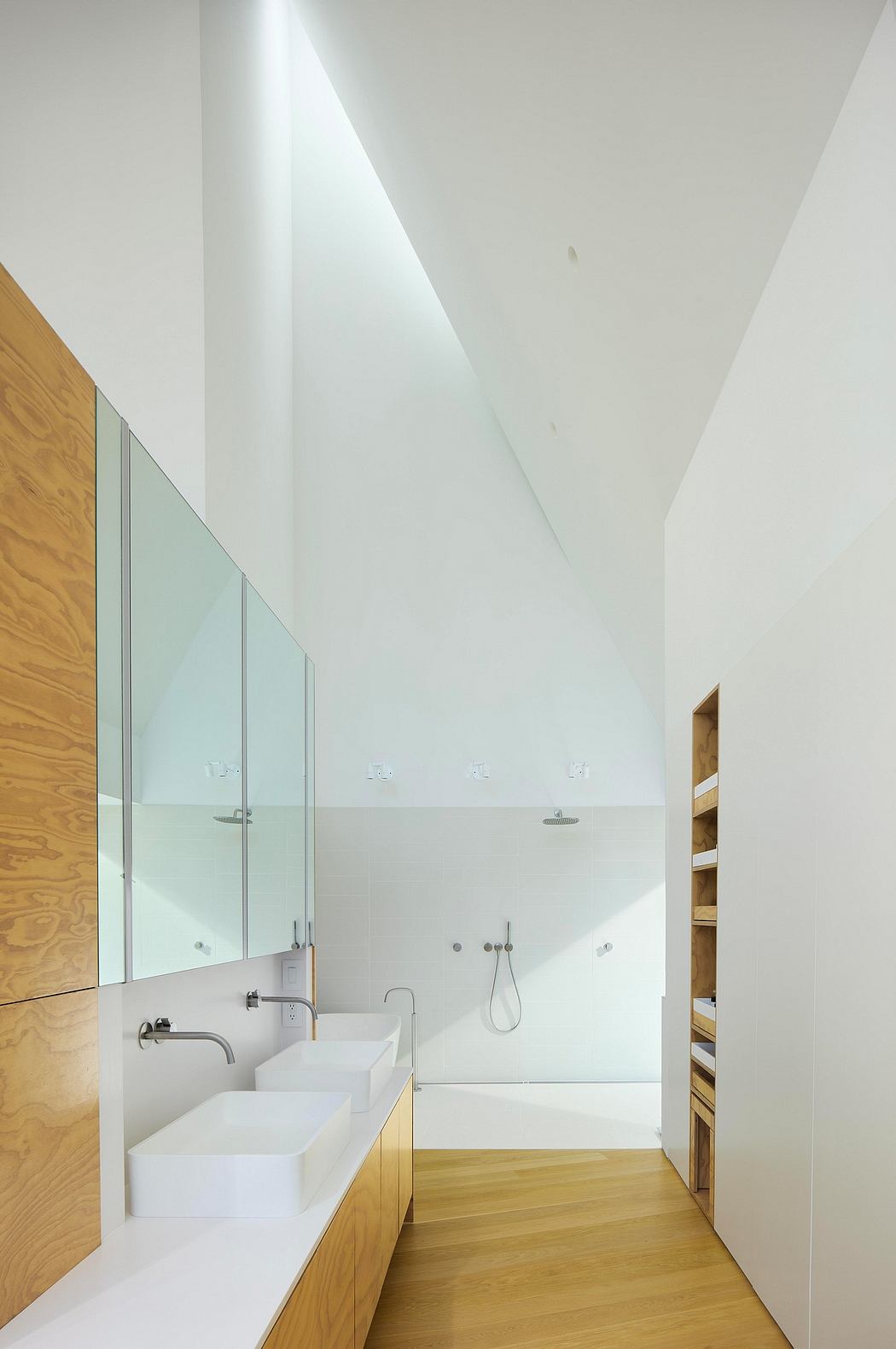 Modern bathroom with minimalist design, featuring a large vanity, glass panels, and wooden accents.