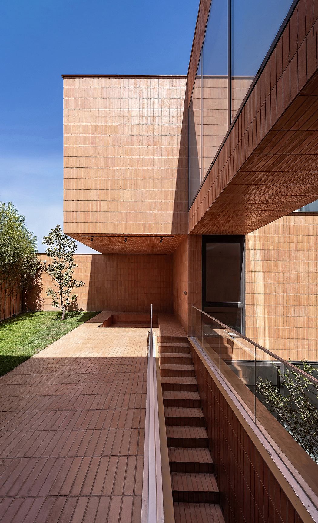Modern architectural design with wooden panels, stairs, and a private backyard.
