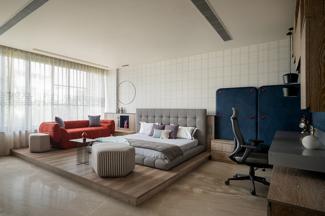 Large open-concept bedroom with patterned bed, plush sofa, and modern furnishings.