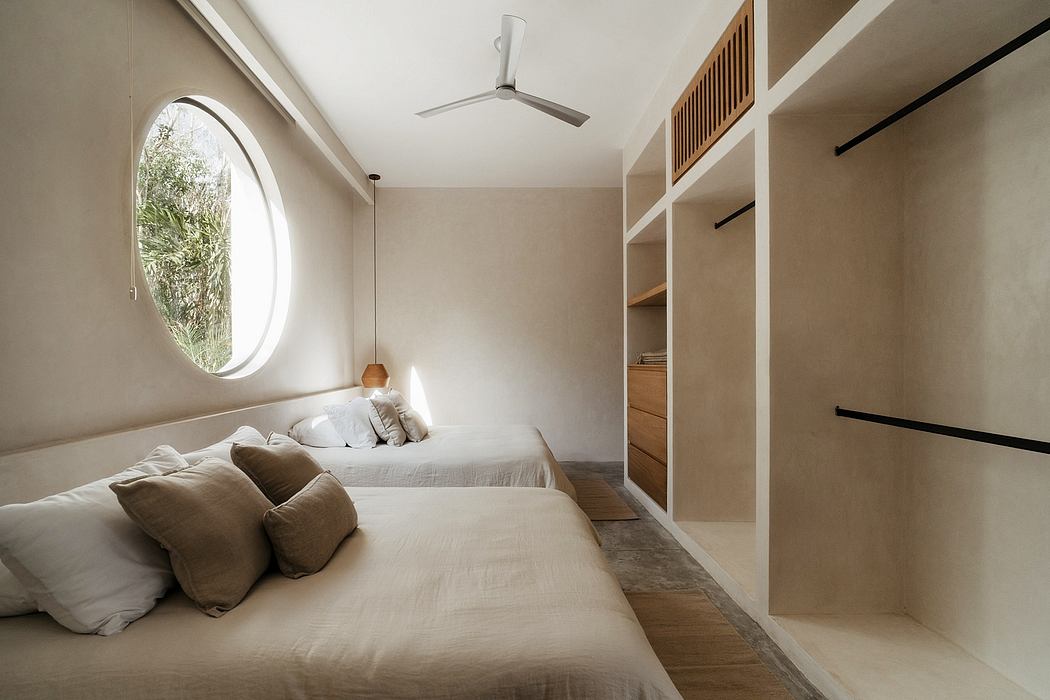 An elegant bedroom with a round window, minimal decor, and built-in shelving.