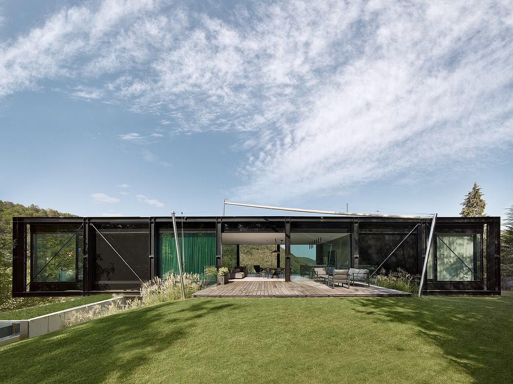Stunning glass and steel architectural home with expansive porch and lush landscaping.