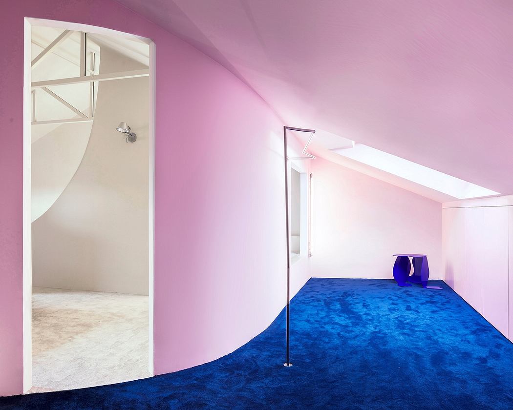 Minimalist room with vibrant pink walls, textured blue carpet, and geometric lighting fixtures.