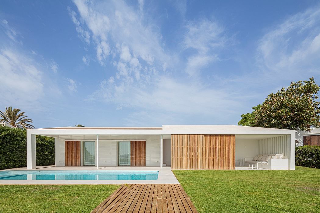 Modern single-story residence with clean lines, wood accents, and a pool on a grassy lawn.