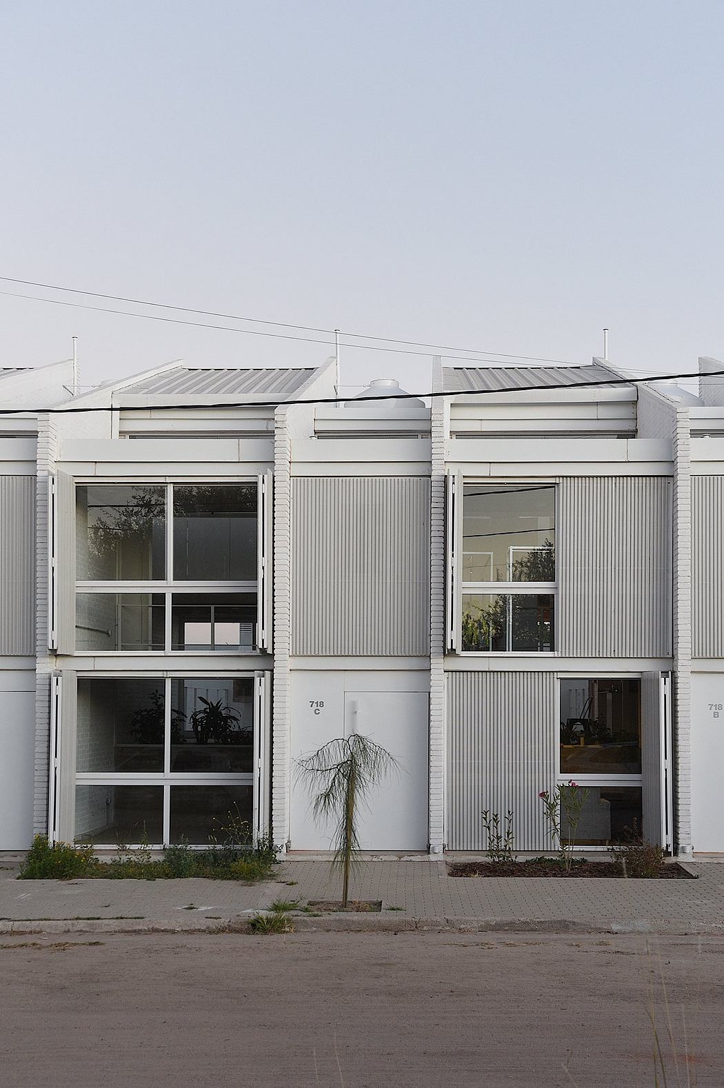 Modern industrial-style building with clean lines, striped facade, and minimalist windows.