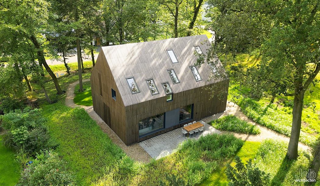 Unique wooden cabin-style home nestled in lush greenery, featuring modern windows.