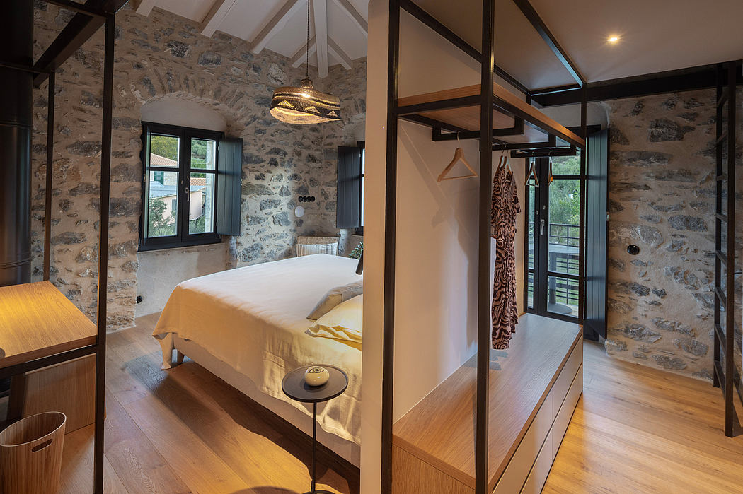 Rustic stone walls, vaulted ceiling, and modern furniture in the stylish bedroom.