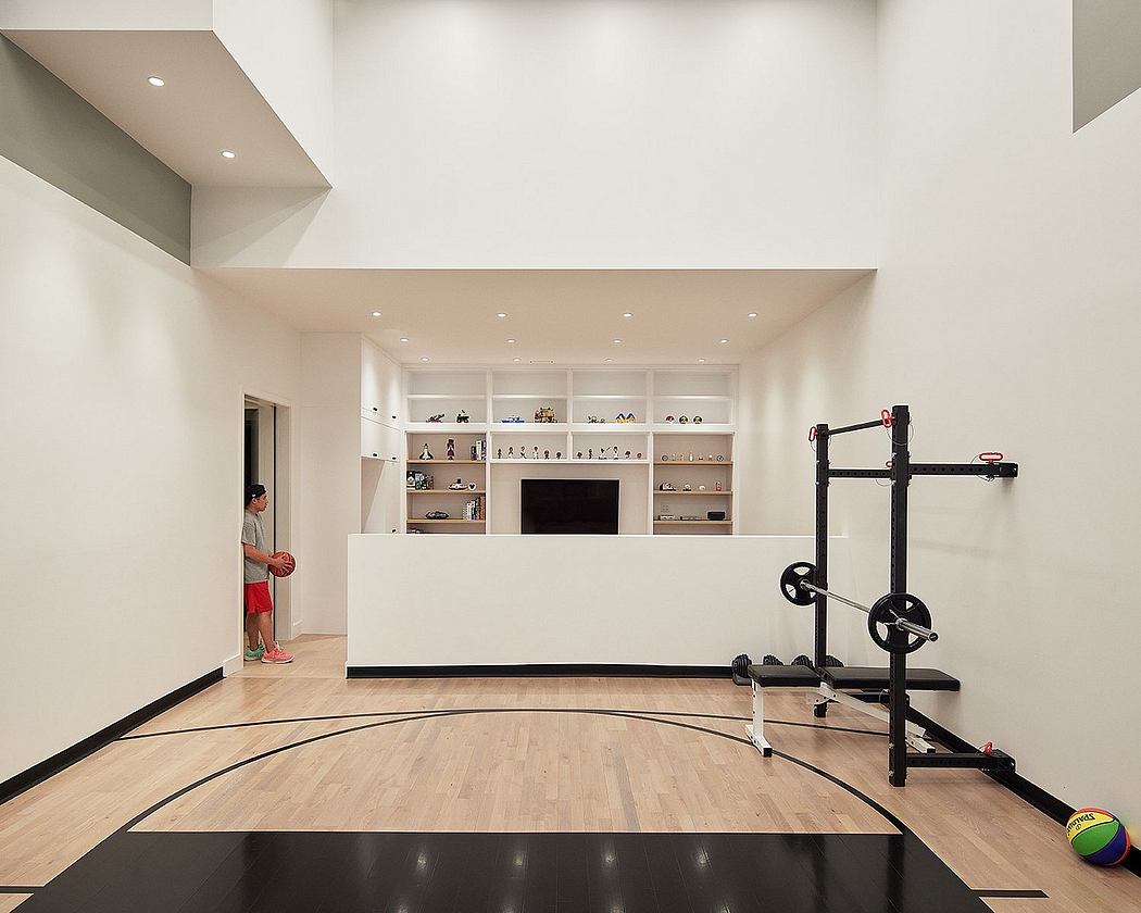 Minimalist home gym with built-in shelves, recessed lighting, and hardwood flooring.