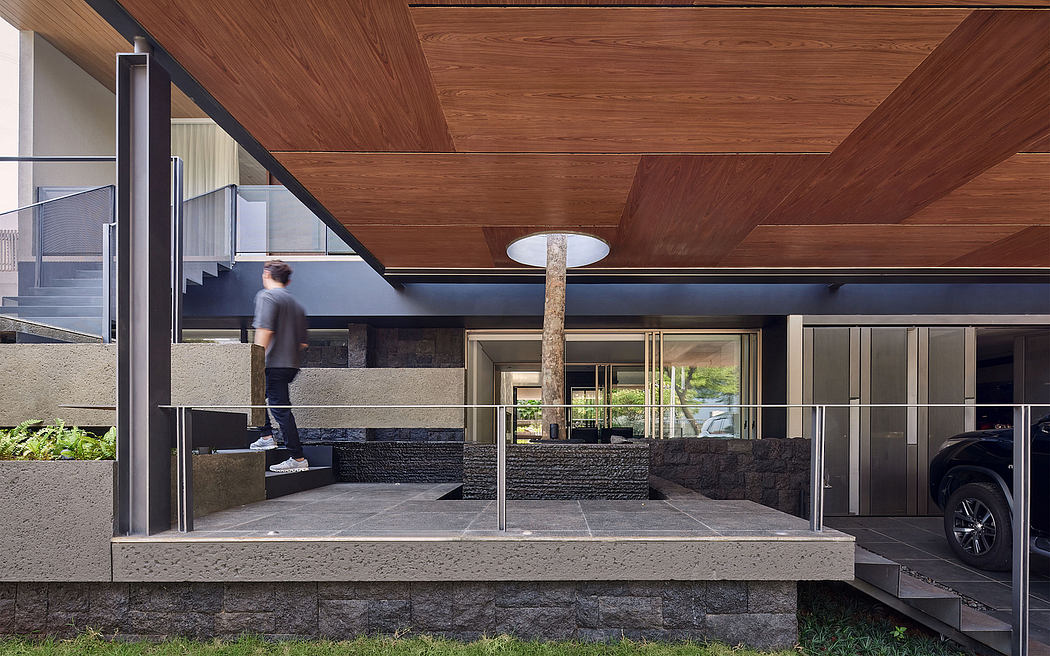 Minimalist modern home with wooden slatted ceiling, glass walls, and stone steps.
