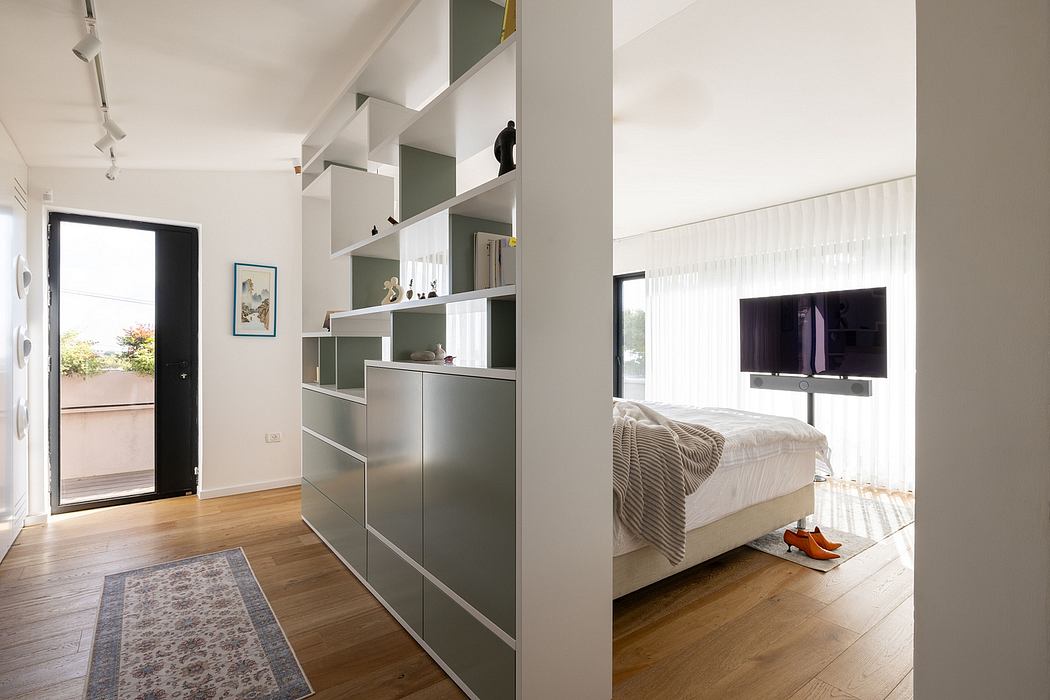 Spacious bedroom with modern, minimalist shelving and storage units dividing the space.
