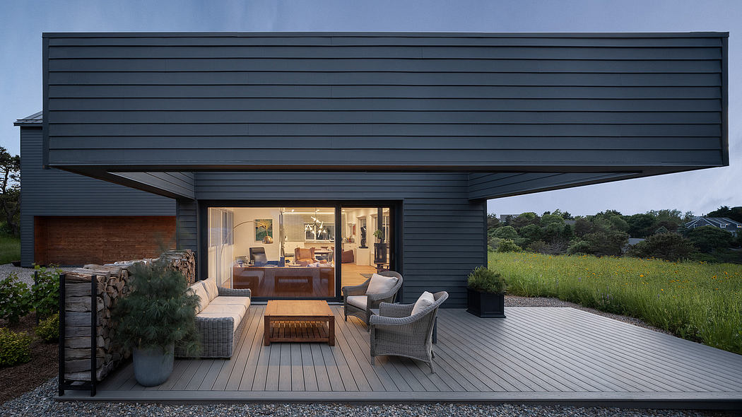 Modern cabin with expansive deck, glass walls, and natural landscaping.