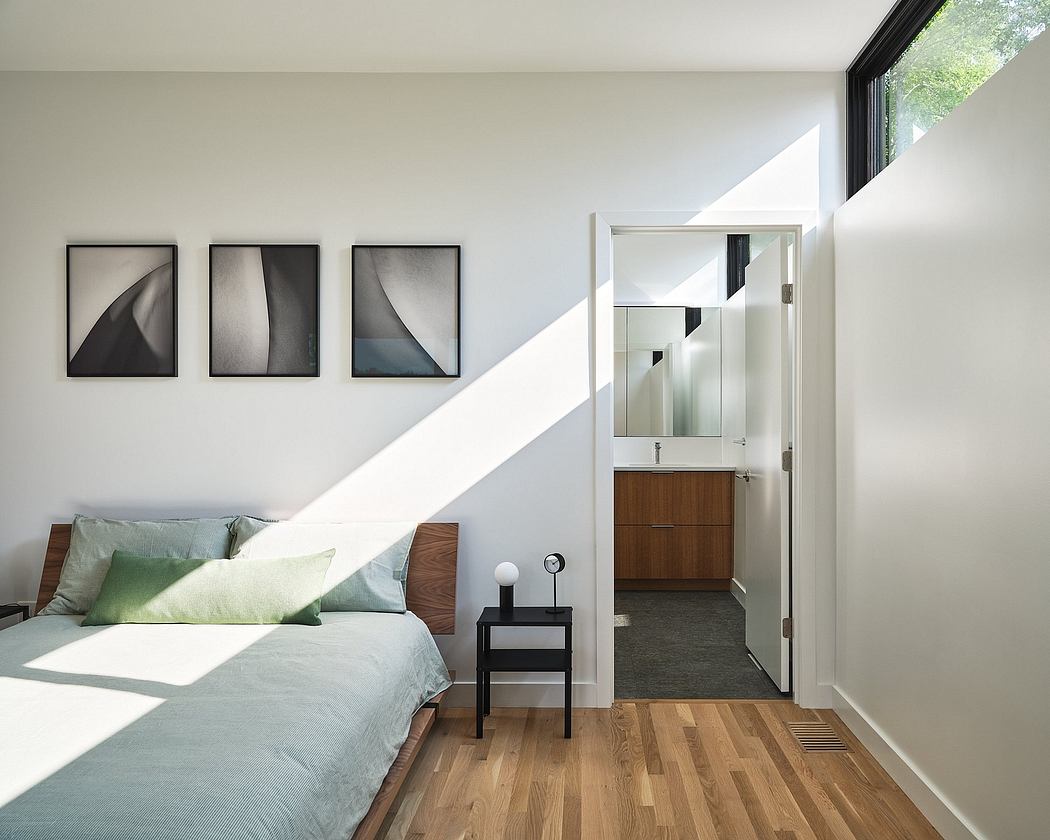 Contemporary bedroom with minimalist decor, wood floors, and framed art on the wall.