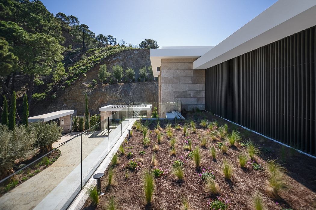 Modern architectural structure with sleek facade, landscaped garden, and glass elements.