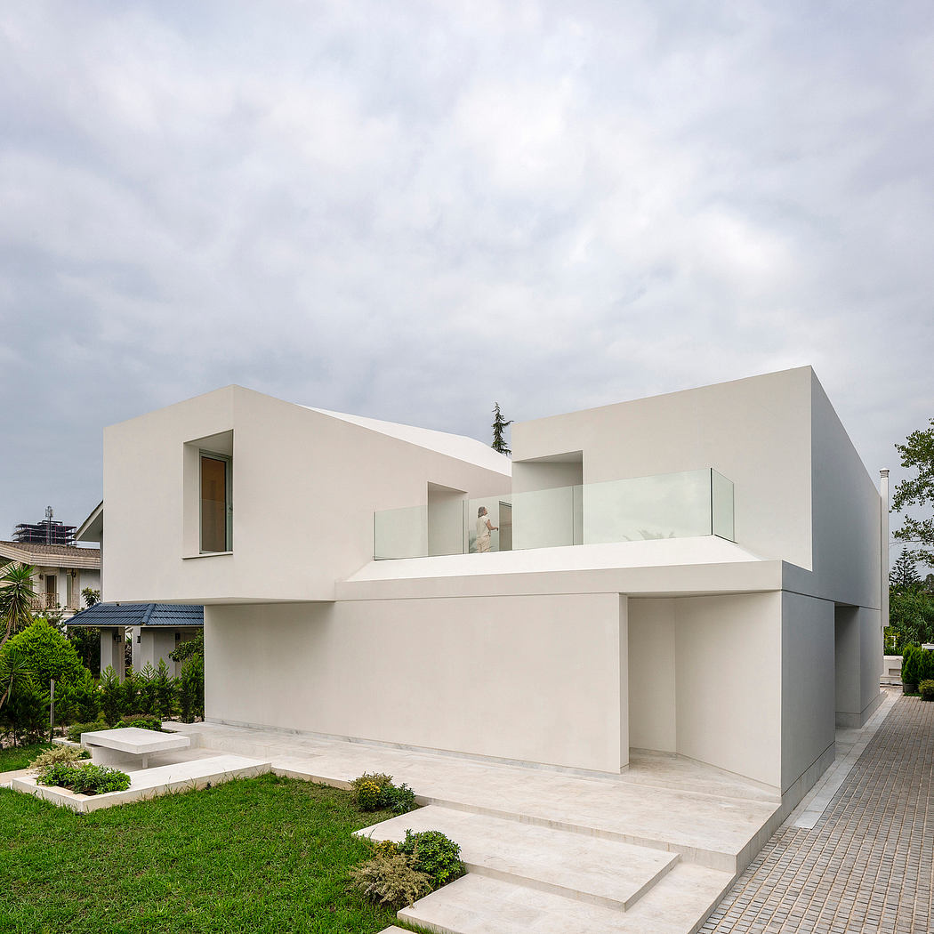 Modern, minimalist residential building with clean lines, large windows, and landscaped garden.