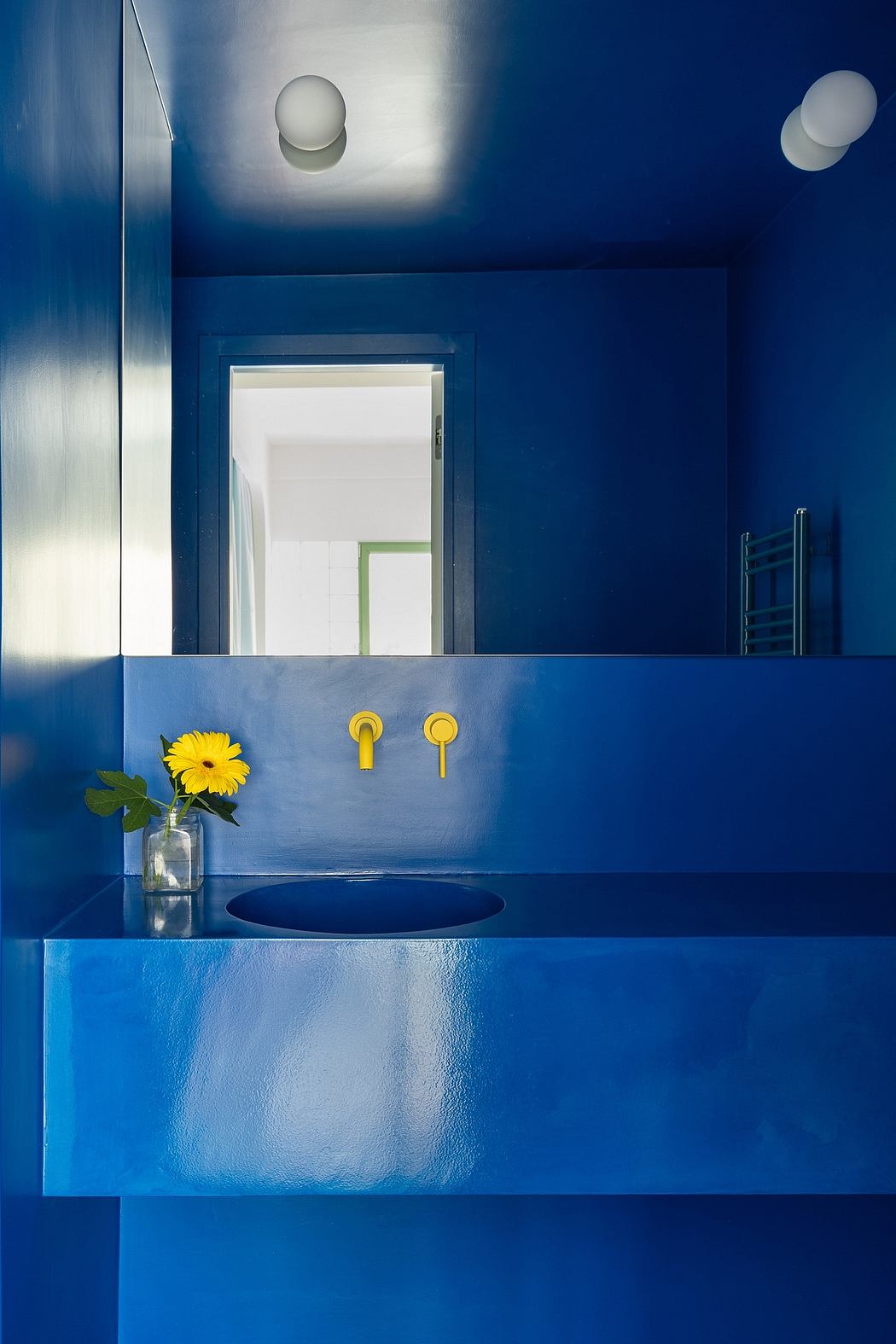 Striking blue-toned bathroom with sleek chrome fixtures and a stylish floral accent.
