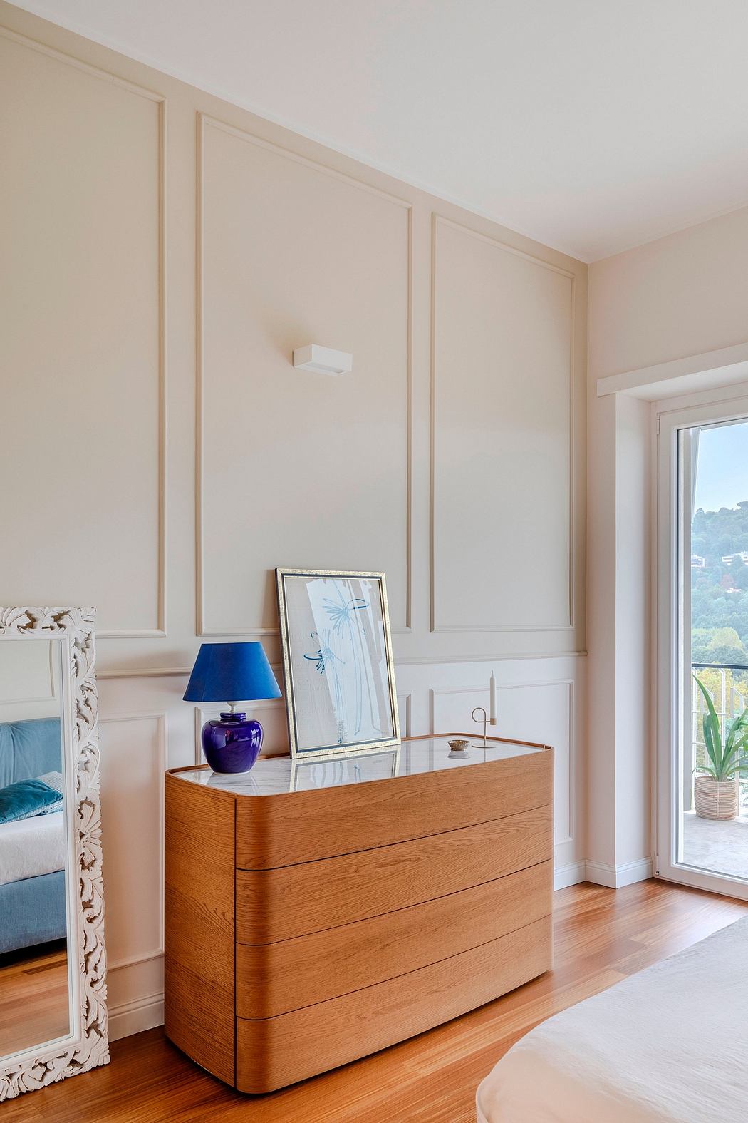 Elegant wooden dresser with decorative mirror and lamp in contemporary room.
