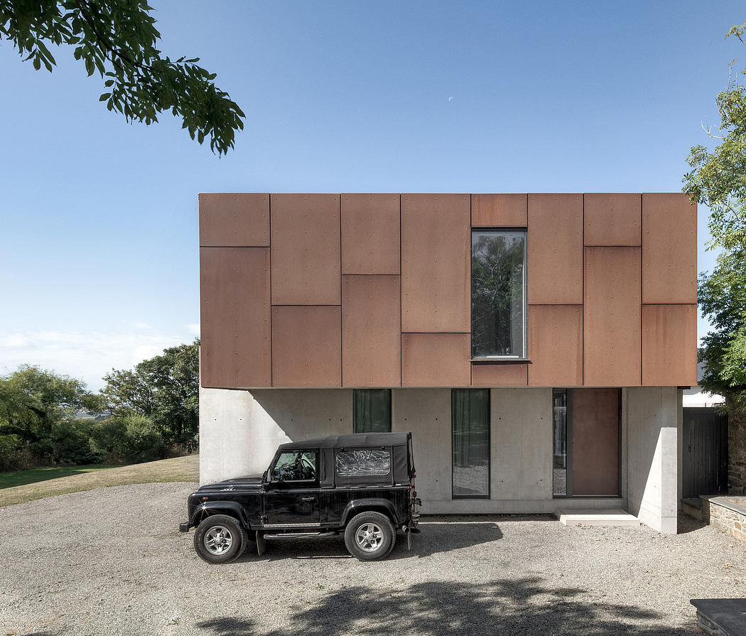 A modern, modular exterior featuring an asymmetrical pattern of brown panels and strategically placed windows.