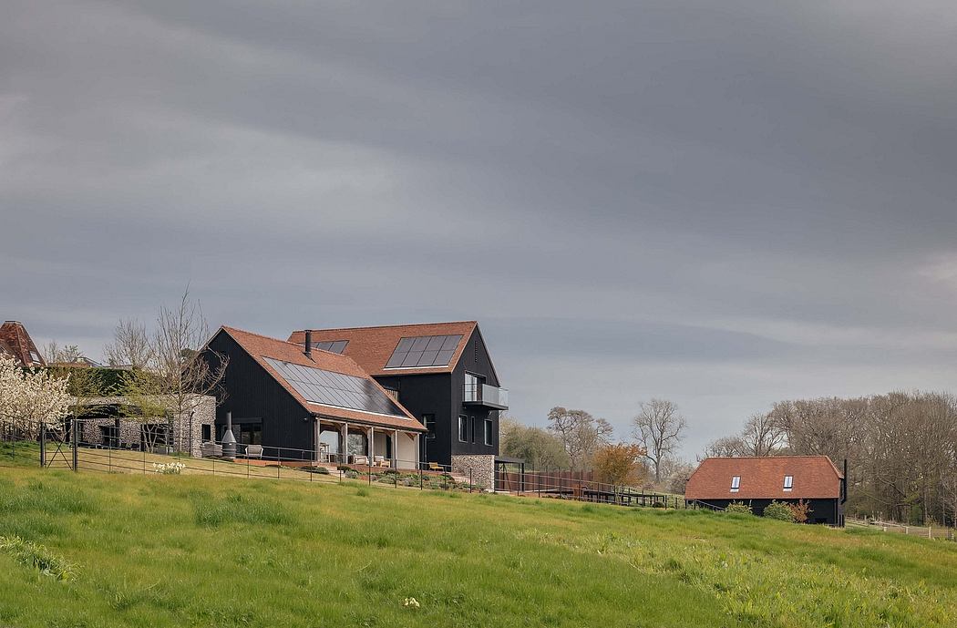 Modern farmhouse-style home with stone and wood exterior, solar panels, and surrounding pastoral landscape.