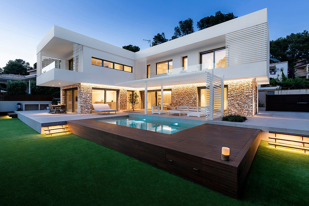 Modern white two-story home with a pool, wood decking, and stone accents. Sleek architectural design.