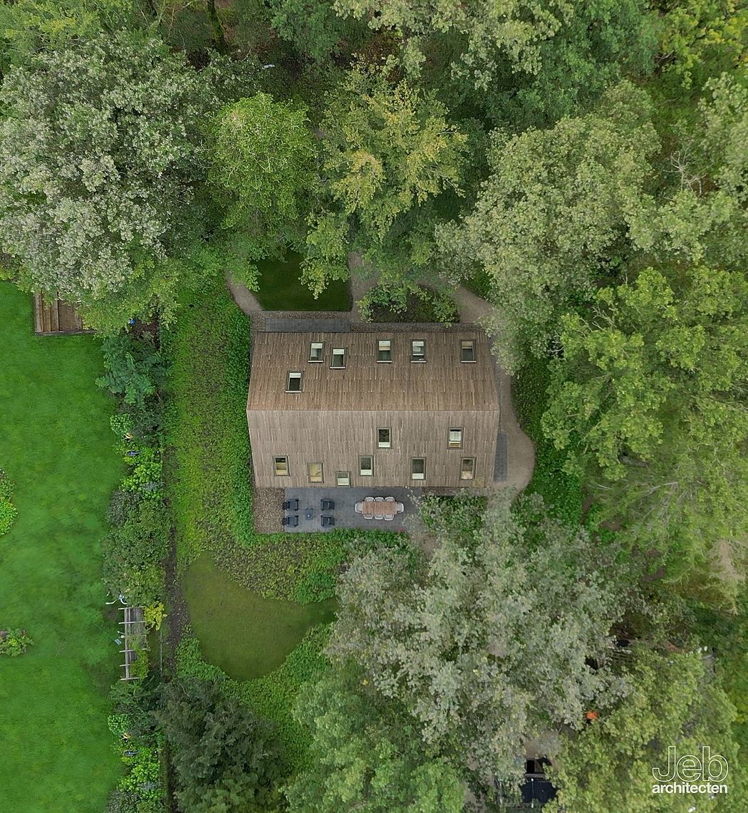An aerial view of a large, multi-story wooden building surrounded by lush greenery.
