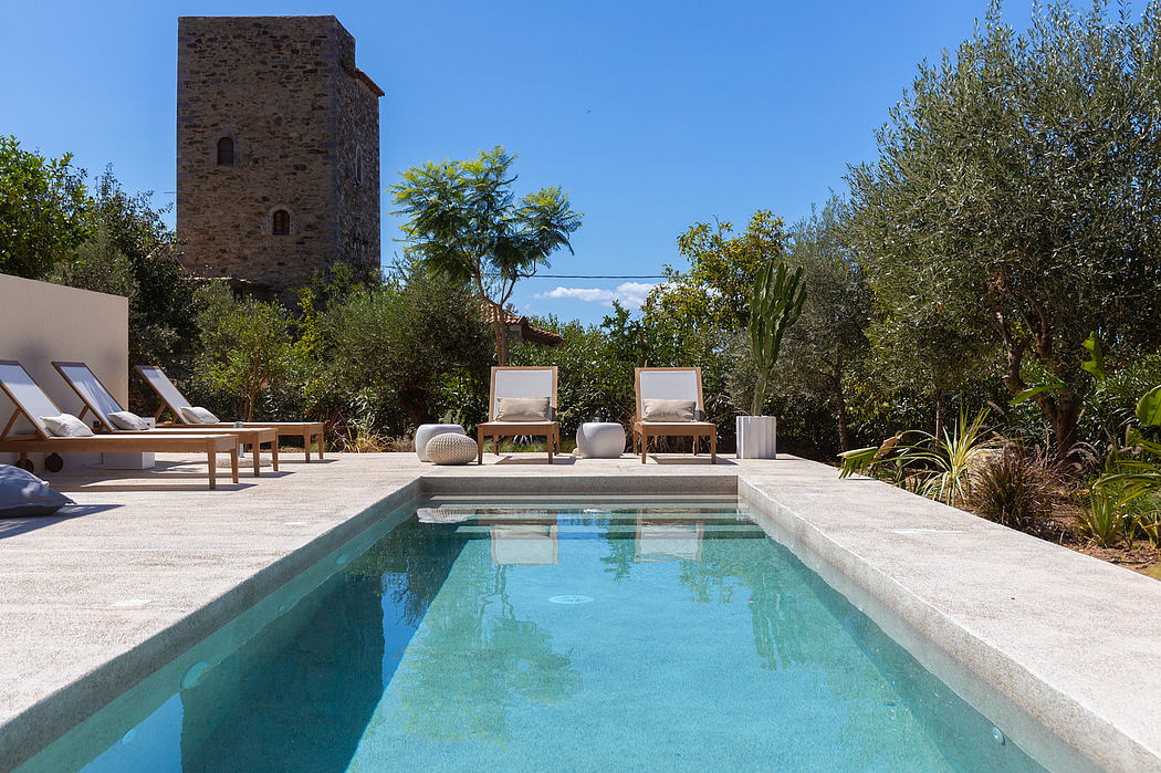 A scenic tower and rustic retreat with a pristine pool and lush Mediterranean landscaping.