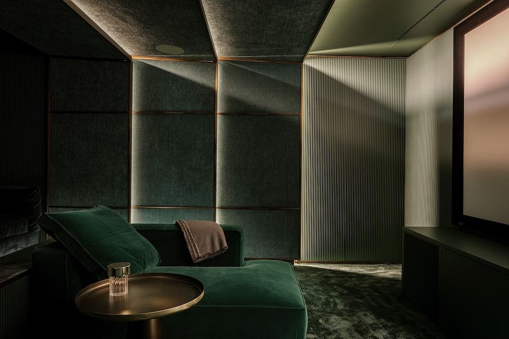 Moody, modern interior with plush green velvet sofa, brass accents, and textured walls.