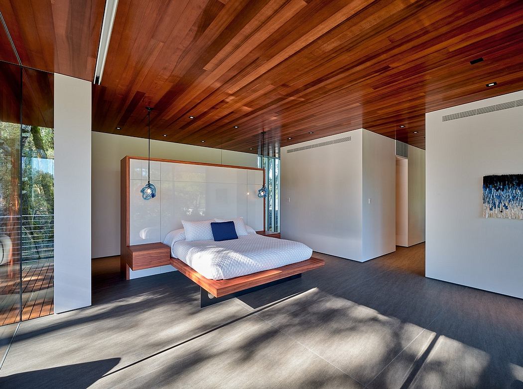 A spacious modern bedroom with a wooden ceiling, large windows, and a floating platform bed.
