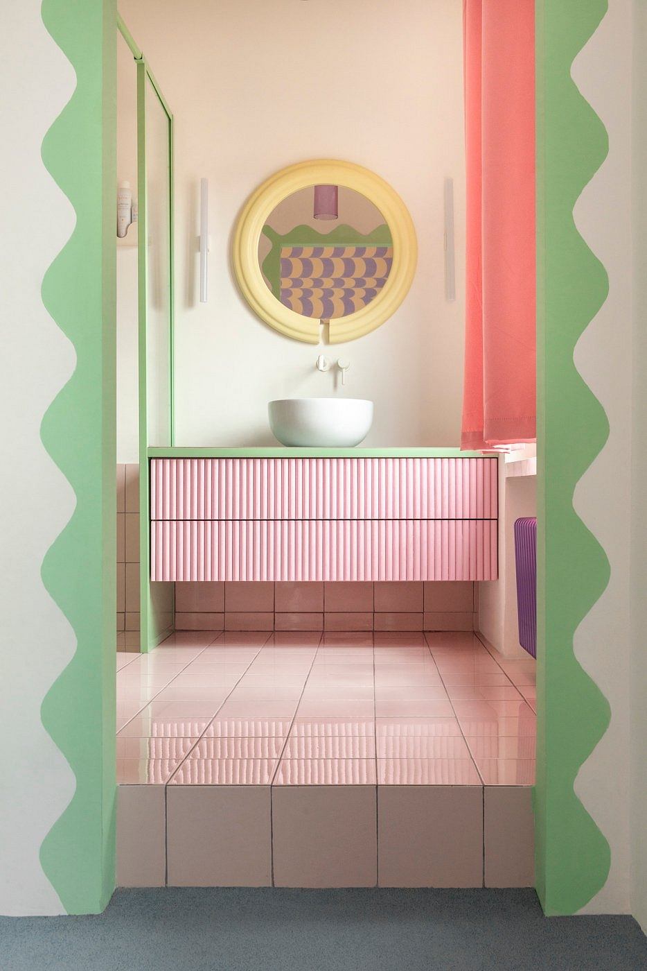 A vibrant, modernist bathroom with pastel colors, geometric patterns, and a striking vanity.