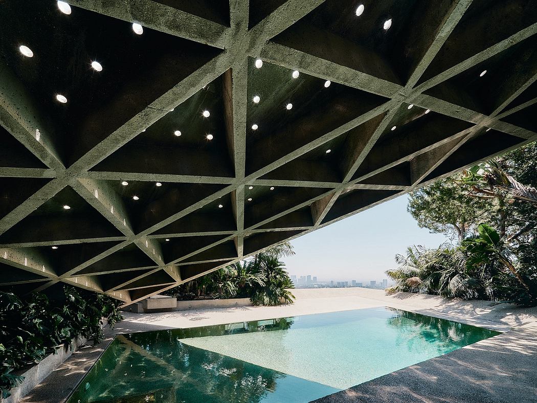 Striking concrete canopy framing an opulent pool with lush tropical foliage.
