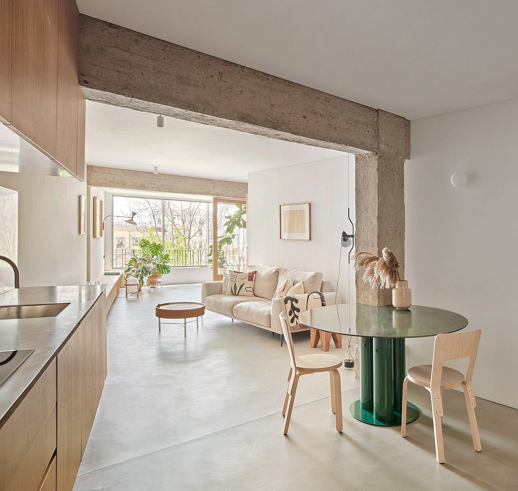 Open-concept living space with exposed concrete beams, modern furnishings, and a cozy seating area.