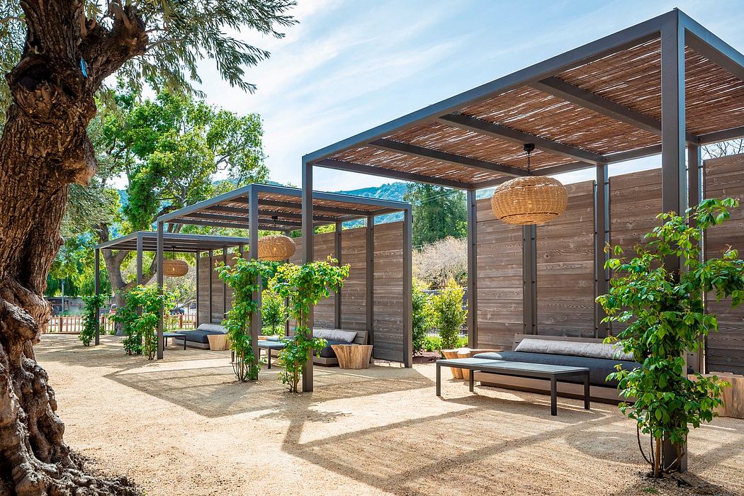 A modern outdoor living space with wooden structures, lush foliage, and natural lighting.