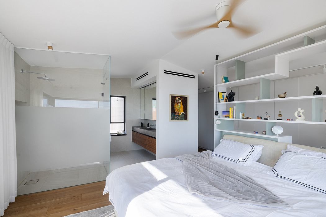 Modern bedroom with minimalist decor, built-in shelving, and en-suite bathroom.