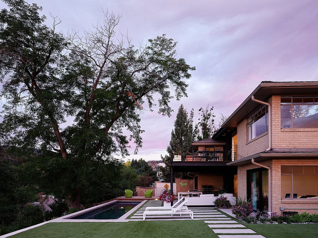 The image depicts a contemporary, multilevel home with a pool, decks, and lush landscaping.