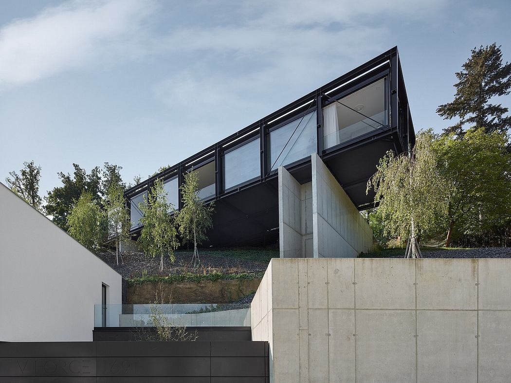 A modern, asymmetrical building with expansive glass walls and concrete foundations.