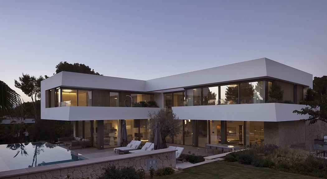 Contemporary two-story home with sleek, angular architecture and large glass windows overlooking a pool.