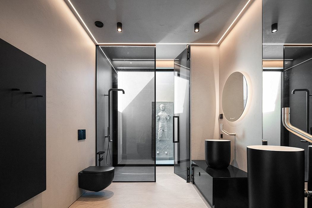 Sophisticated bathroom with sleek black fixtures, frameless glass shower, and oval mirror.