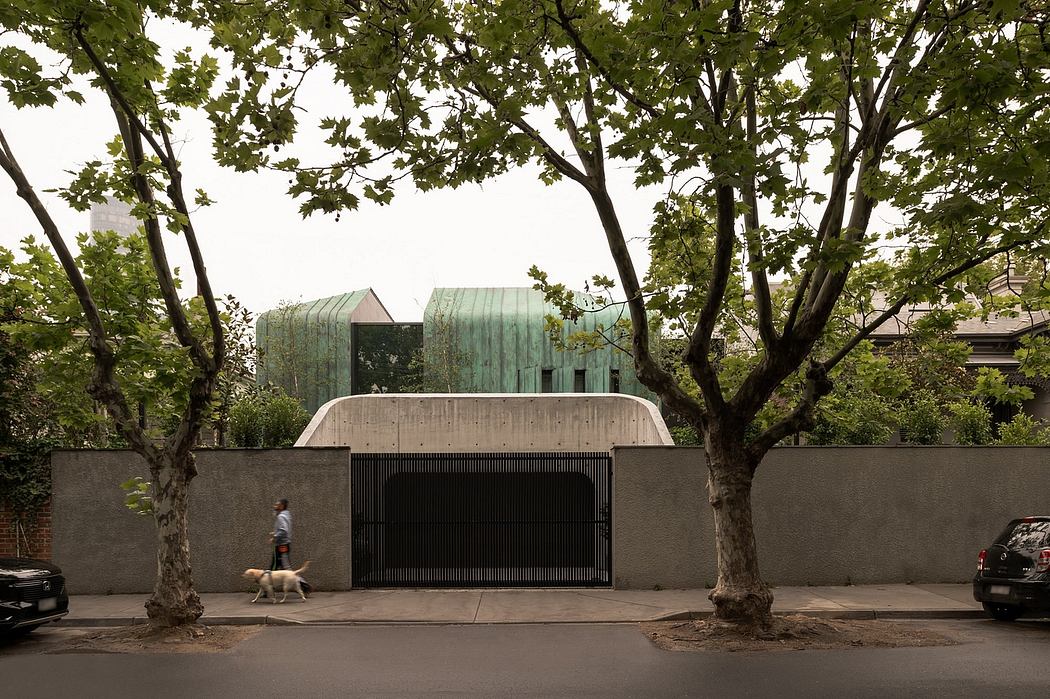 Large modern building with distinctive copper-colored roofs, nestled between trees.